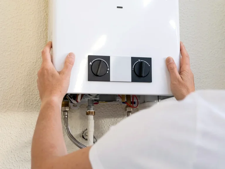 Technician mounting a tankless gas water heater on a wall